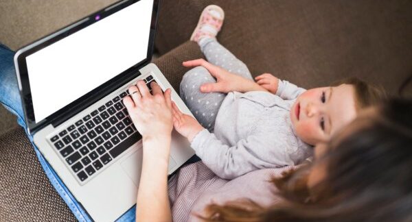 As melhores lojas de bebê on-line do Brasil - Mujer revisando la computadora portatil con un bebe en sus piernas