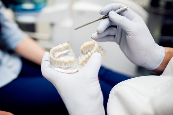 Dentista explicando a um paciente sobre seu tratamento odontológico - Melhores clínicas de prótese dentária no Brasil 