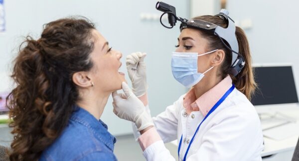 otorrinolaringologistas - Otorrinolaringologista realizando uma verificação em um paciente